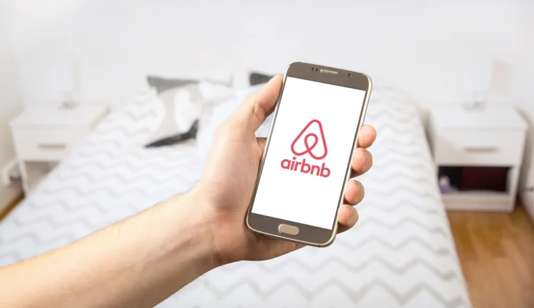 Hand posing smartphone showing Airbnb